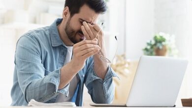 Pessoa utilizando computador em ambiente interno, evidenciando o uso prolongado de telas.
