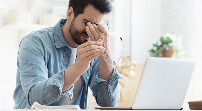 Pessoa utilizando computador em ambiente interno, evidenciando o uso prolongado de telas.