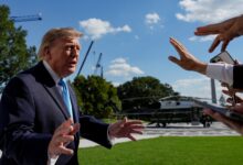 Donald Trump falando à imprensa com helicóptero ao fundo.