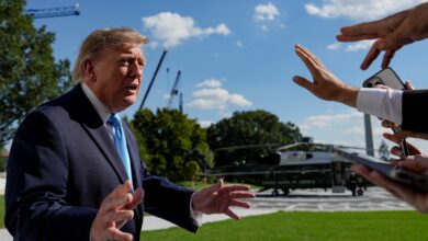 Donald Trump falando à imprensa com helicóptero ao fundo.