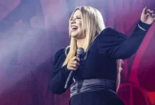 Marília Mendonça em um show, segurando o microfone.