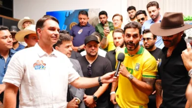 Flávio Bolsonaro ao lado de artistas sertanejos em evento de campanha em Goiânia.