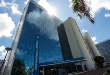 Prédio do Conselho da Justiça Federal com bandeiras do Brasil ao fundo.