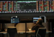 Bolsa de Valores durante pregão com gráficos de ações em queda.