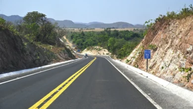 Máquinas e operários trabalhando em obras de pavimentação de rodovia em Goiás.