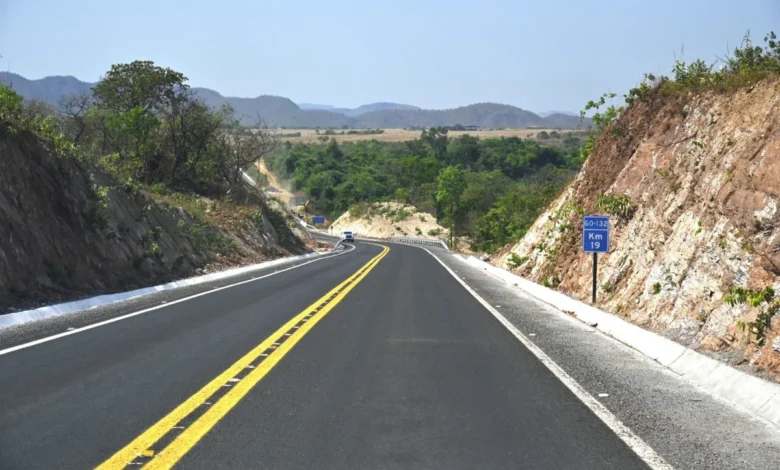 Máquinas e operários trabalhando em obras de pavimentação de rodovia em Goiás.